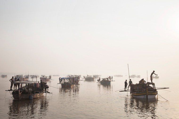 Sand mining boats work illegally on the Thane River near Nagla Bunder Village in Maharashtra, India, March 20, 2013. Photo by Adam Ferguson for WIRED