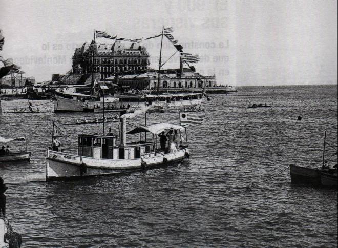 Races organized by the Montevideo Rowing Club in Montevideo Bay. The Hotel Nacional, in the background, was one of the greatest schemes of the National Company of Credit and Public Works. Victim of the 1890 crisis, the building was never operational, and the French manager stayed some years in the empty hotel waiting for an inauguration that never happened.